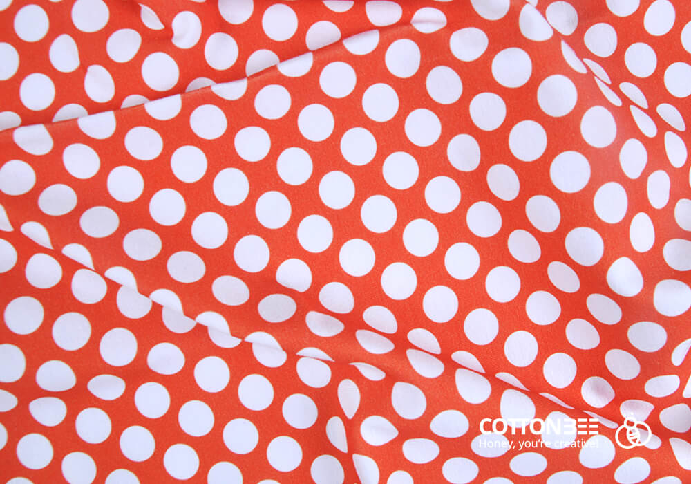 Picture of orange fabric printed with white polka dots