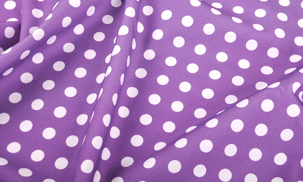 Picture of purple fabric with white polka dot print